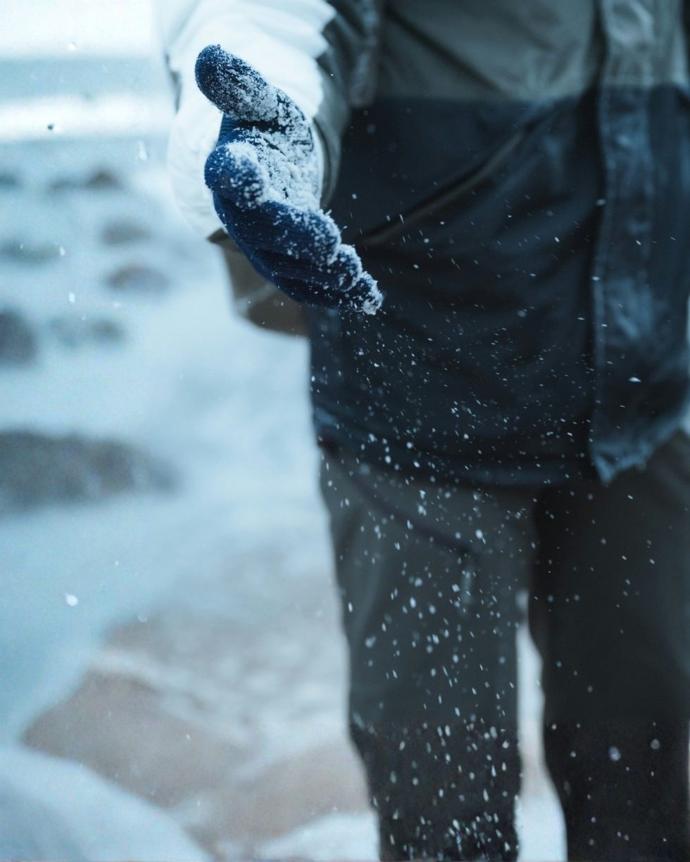 Gloved hand reaching out over fresh snow